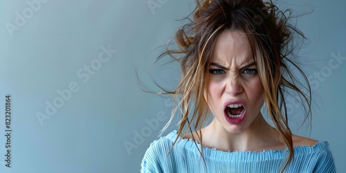 Portrait of furious young woman yelling against gray background. Concept Portrait Photography, Emotion, Anger, Gray Background, Facial Expression
