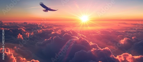 A majestic sunrise over the clouds, with an eagle soaring high above in flight