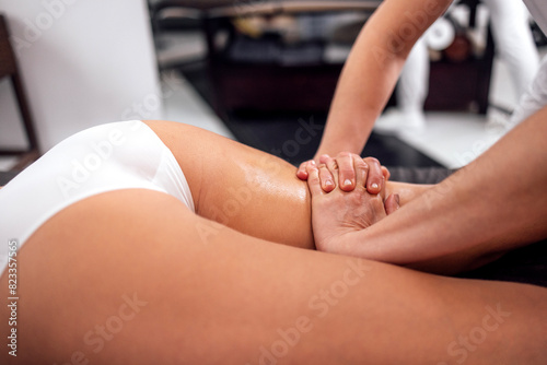 Masseuse makes anti cellulite massage of buttocks, thighs and legs to her client