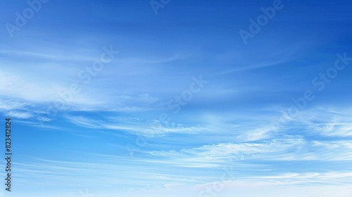 Serene blue sky with wispy clouds. Vibrant blue sky adorned with wispy white clouds, creating a tranquil and ethereal atmosphere.