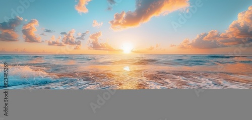 Tranquil beach scene at sunrise, with gentle waves lapping at the shore and the sky transitioning from night to day