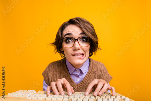 Photo portrait of attractive young woman type keyboard nervous bite lips dressed retro office clothes isolated on yellow color background
