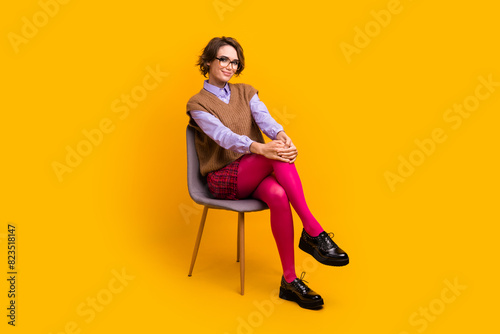 Photo portrait of attractive young woman sit chair confident pose dressed retro office clothes isolated on yellow color background