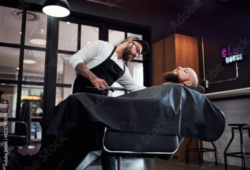 Hair care, client and man in barbershop with chair, cut and tools for trendy hairstyle trim at small business. Style, barber and customer in shop for grooming service, haircut skills and clean shave