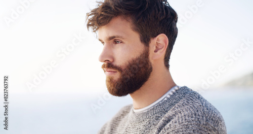 Man, thinking and outdoor view at beach for holiday adventure or summer vacation, brainstorming or decision. Male person, thoughts and question wondering at seaside coast, travel or contemplating