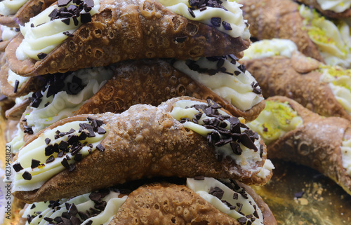 Sicilian cannoli filled with ricotta and garnished with pistachio granules and chocolate chips for sale in Sicily