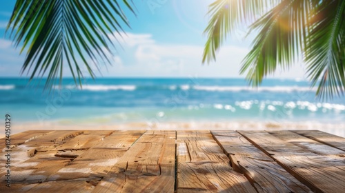 A wooden table surrounded by sandy beach and tall palm trees against a clear blue sky