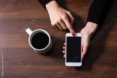 スマートフォンを操作する女性の手とコーヒー