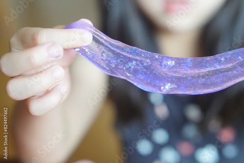 手作りスライムで遊んでいる小学2年生（8歳）の女の子。可愛らしい紫色のスライムを作ったよ。