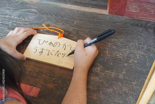 白根大明神で絵馬を書いている小学一年生の女の子