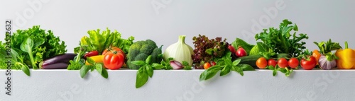 Colorful assortment of fresh vegetables including lettuce, bell peppers, tomatoes, and greens, arranged neatly on a white background.