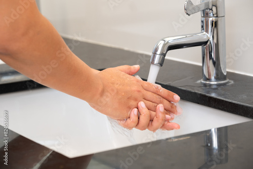 hand of beauty woman wash your hands at the wash basin with foam, cleanse the skin and have water flowing through the hands. Health and beauty concepts 