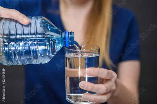 Pić wodę, woda źródlana nalewana z plastikowej butelki do szklanki