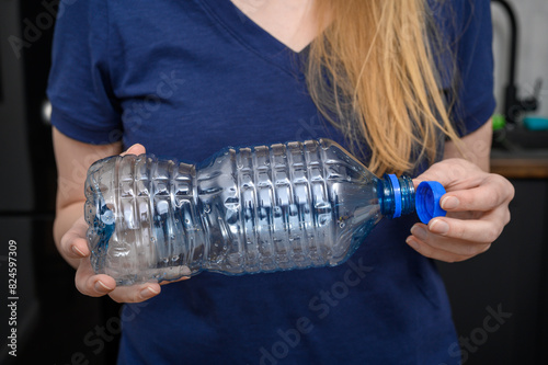 Pusta plastikowa butelka po wodzie trzymana w dłoniach, sposób wykorzystania