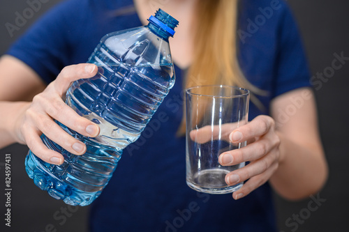 Woda gazowana w plastikowej butelce szklanka w dłoni, nalewać wodę zbliżenie
