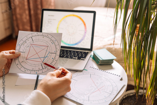 An astrologer draws with a pencil on a natal chart.