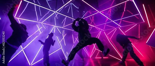 A group of four dancers perform a contemporary dance routine in a neon-lit room