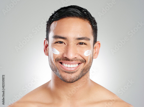 Portrait, wellness and man with cream, skincare and dermatology on grey studio background. Face, person or model with cosmetics, luxury or creme for healthy skin, lotion and beauty with facial or joy