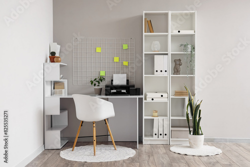 Interior of office with workplace, pin board and printer