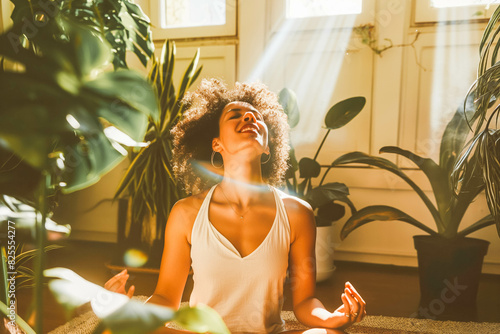 Joyful woman doing yoga in sunlit living room, plants and natural elements surrounding her.