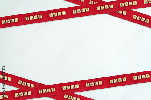 クロスされたSALEの英語ブロックが繰り返し並ぶ赤いテープが上下に貼られた装飾フレーム