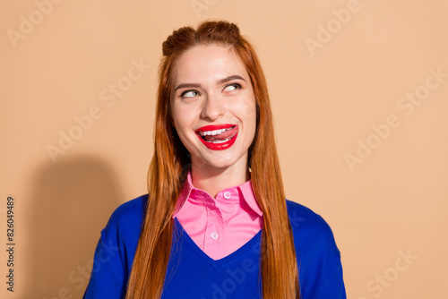 Photo of positive funky lady wear blue jumper stick out looking empty space isolated beige color background