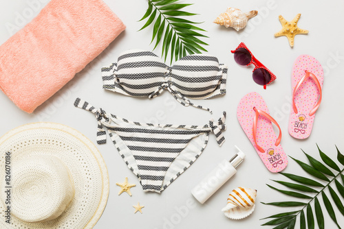 Woman swimwear and beach accessories flat lay top view. Top view with bikini outfit on color background. Vacation concept copy space
