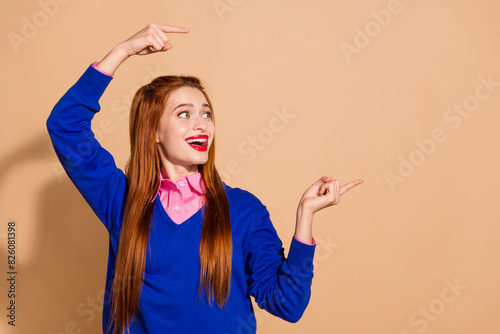 Photo of cheerful excited lady wear sweater showing fingers looking empty space isolated beige color background