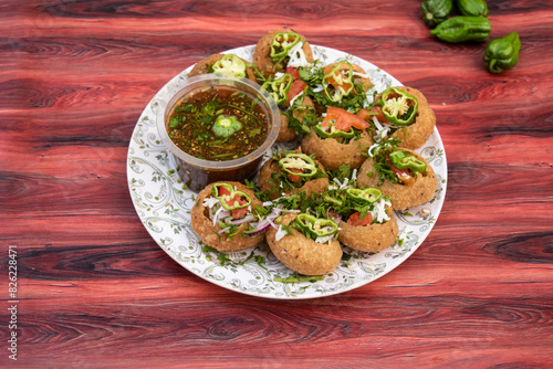 Naga Fuchka, pan puri, or gol gappa filled with herbs with spicy water served in plate isolated on wooden table side view of bangladeshi street food