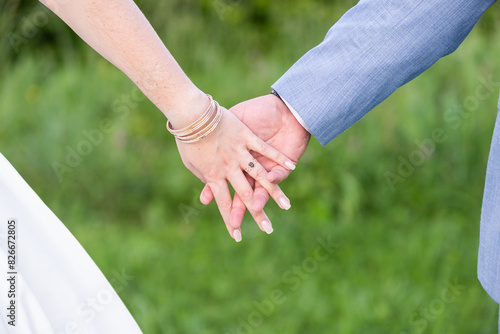 Les mariés main dans la main pendant leur mariage