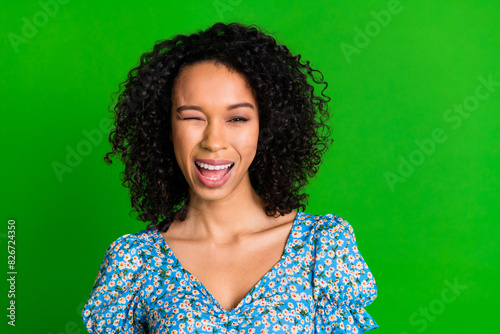 Photo of cheerful sweet lady blue top winking you eye empty space isolated green color background