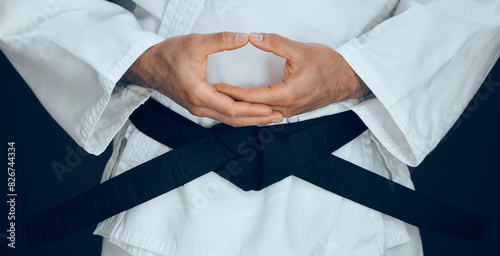 Karate, hands and black belt in studio for master, exercise and training in fighting. Person, martial arts and professional fighter in dojo for sport, expertise or sensei in self defense or taekwondo