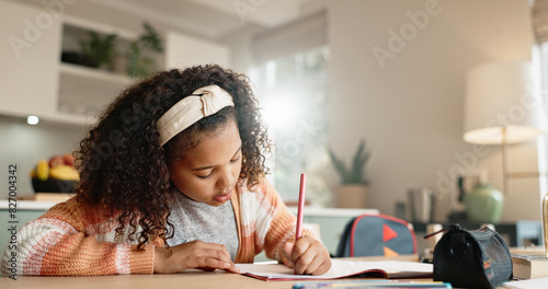 Little girl, student and writing with book in kitchen for homework or assessment at home. Young female person, child or kid taking notes or studying with stationery for learning or education at house