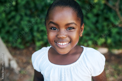Relax, smile and portrait of black child in garden for outdoor adventure, weekend and summer vacation. Kid, little girl and joyful in nature park for break, happiness and holiday fun in Nigeria