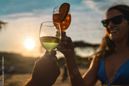 Cheers at Sunset on the Beach - Celebrating Summer Moments - happy couple toasting drinks