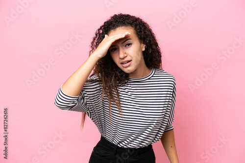 Young hispanic woman isolated on pink background looking far away with hand to look something