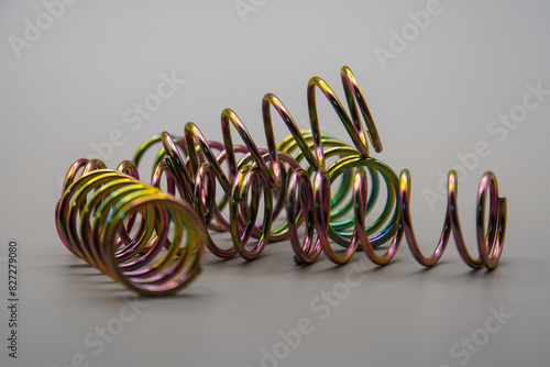 steel compression coil springs with varied surface finish isolated on grey background. Springy metallic machine parts. Set of different flexible elastic shock absorbers with spiral wire winding.