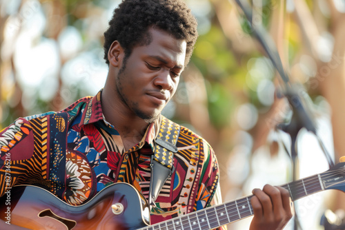 African American Musician Playing Guitar in Outdoor Setting.