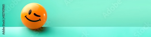 winking emoji on a mint green background with space for copy The emoji is bright orange, adding a playful touch