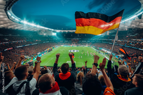 A vibrant crowd waving a German flag and cheering during a Euro 2024 soccer match in Germany. The stadium is filled with excitement and national pride