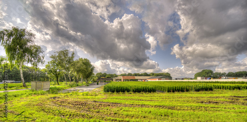 A formation of massive clouds gathers above a rural landscape in The Netherlands.
