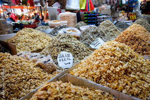 various anchovies displayed at traditional market. various kinds of dried anchovies and shrimps in containers for sale at traditional markets. 