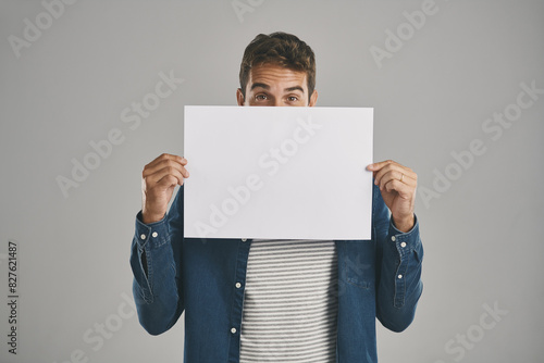 Man, portrait and poster or information mockup in studio for announcement placard, advertising or grey background. Male person, banner and billboard sign for deal or bulletin, ambassador or choice