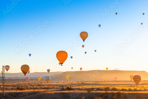 Colorful hot air balloons over the mountains in Cappadocia, Turkey. Beautiful landscape at sunrise.