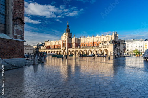 Renaissance Cloth Hall on Krakow Main Square reflecting in the wet cobblestones, sunny morning, Cracow, Poland.