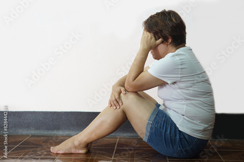 Sad and depressed woman sits on the floor, knee up and cover her face with hand. Concept, Psychological mental health problems. Depression disorder. Life crisis . 