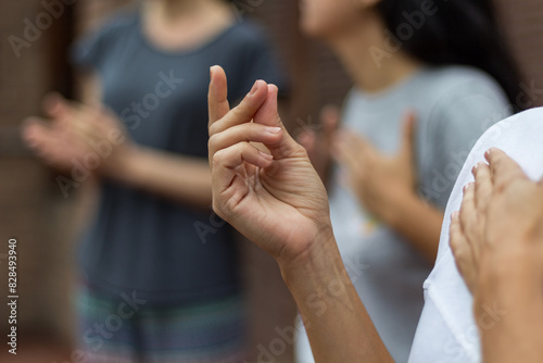 People doing percussion with their bodies. A hand in the foreground making a clicking sound