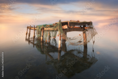 Rustic table with fishing tackle in the Ebro Delta, Tarragona, at dawn over the Mediterranean Sea