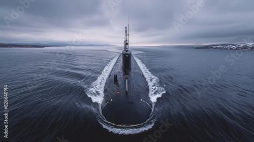 A submarine cruises through calm waters under a cloudy sky, creating a wake as it moves. The distant shoreline and snow-covered mountains add serenity.