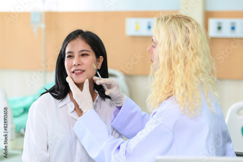 Woman doctor cosmetologist injects a filler into the cheek of the patient's woman. Cosmetology concept.